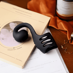 Black massage tool on a book with a blurred background