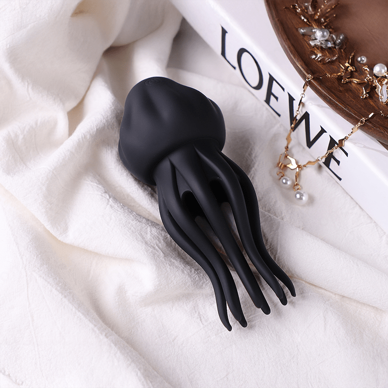Black jellyfish-shaped Penis Trainer on a white fabric background with 'LOEWE' branding.