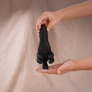 a hand hold a black penis trainer
