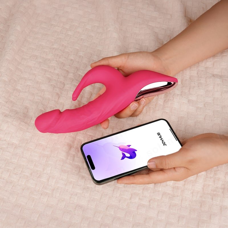 A hand hold a pink rabbit vibrator with a phone app