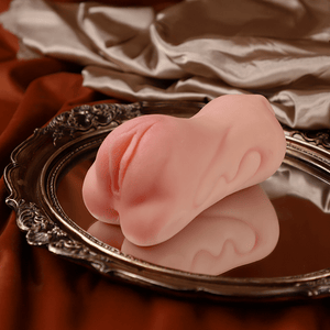 Pink pocket pussy on a decorative silver tray with a brown fabric background