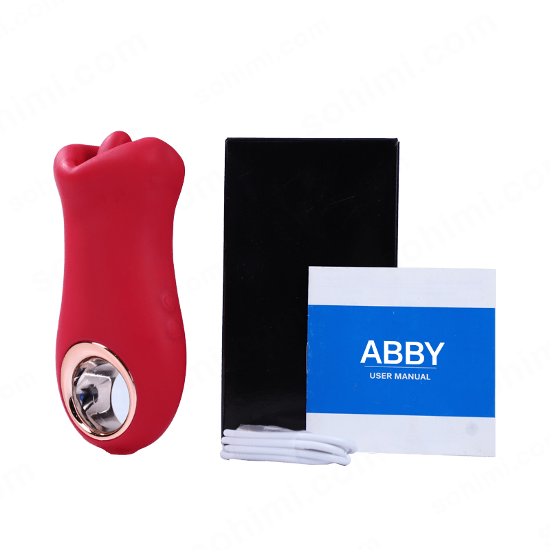 Red tongue licking vibrator with black box and blue 'ABBY' manual on a green background with 'sohimi.com' text.