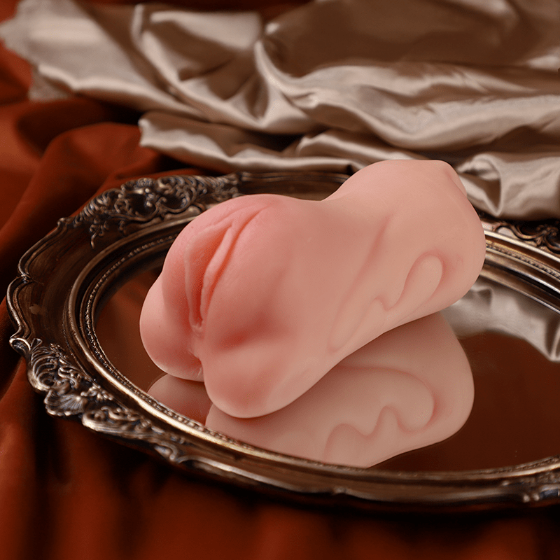 Pink pocket pussy on a decorative silver tray with a brown fabric background